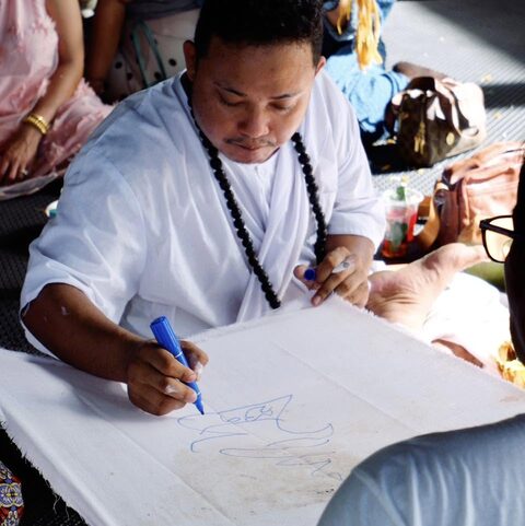 A master draws the yantra on cloth during the opening ceremony